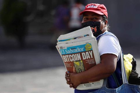 Eine Frau verkauft Zeitungen, die den Start von Bitcoin in El Salvador verkünden, September 2021