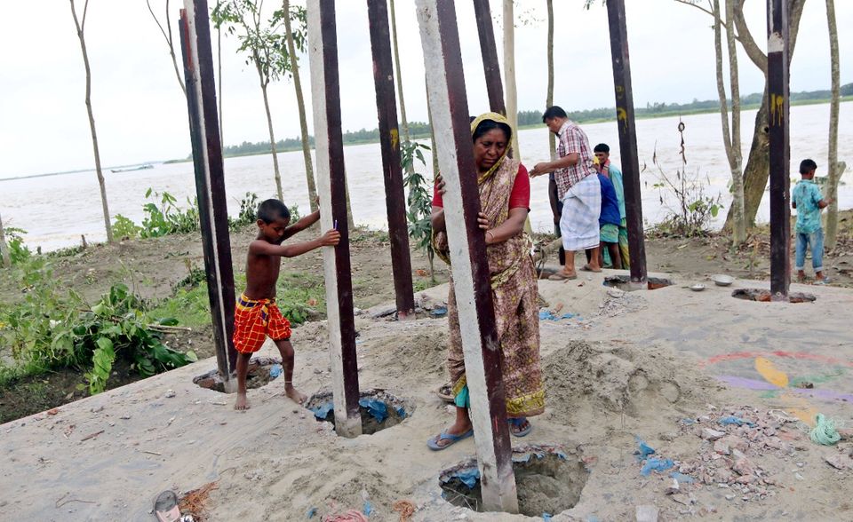Umzug in Bangladesch. Weil Fluten und Sturzbäche die Ufer erodieren müssen Anwohner neue Behausungen bauen.