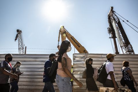 Fußgänger gehen in Brasilien an einer Baustelle vorbei