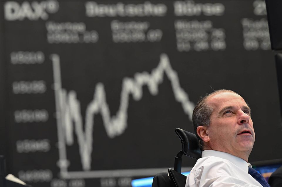 Wertpapierhändler Arthur Brunner von der ICF Bank blickt an seinem Arbeitsplatz auf dem Parkett der Frankfurter Wertpapierbörse vor der Anzeigetafel mit der Dax-Kurve auf seine Monitore. Nach dem Kurssturz zum Wochenstart hat sich der deutsche Aktienmarkt ein wenig gefangen.