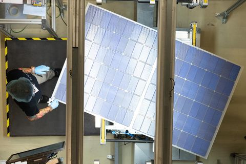 Eine Mitarbeiterin steht bei der Qualitätskontrolle an einer Produktionslinie für Solarmodule im Werk der Meyer Burger Technology AG.