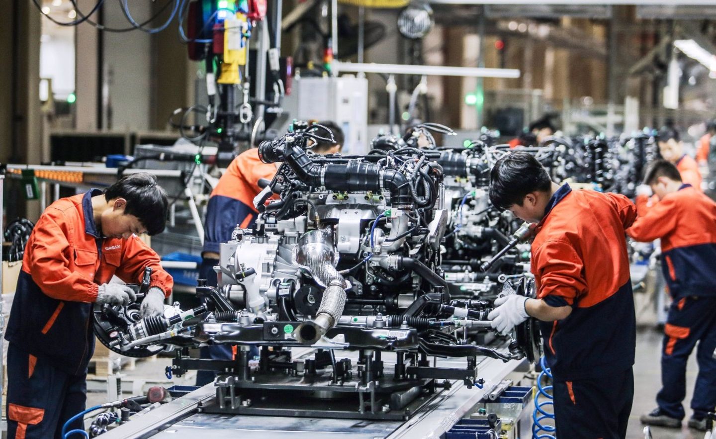 Chinesische Arbeiter bei der Montage von Motoren in einem Werk von Geely Auto in Baoji in der Provinz Shaanxi.