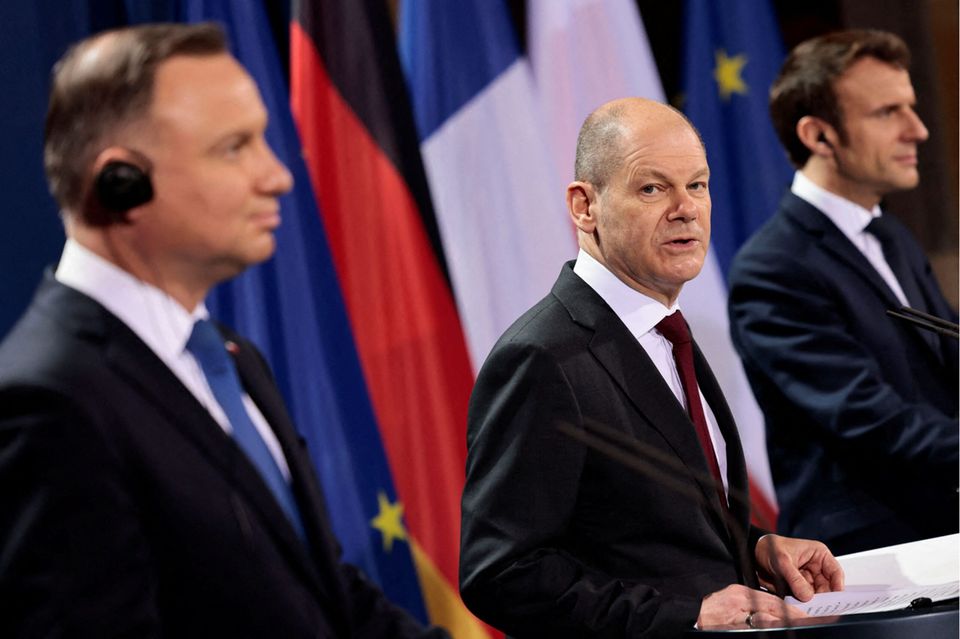 German Chancellor Olaf Scholz (C) speaks during a joint press conference with France's President Emmanuel Macron (R) and Poland's President Andrzej Duda (L) ahead of a Weimar Triangle meeting at the chancellery in Berlin, on February 8, 2022. - German Chancellor Olaf Scholz hosts the Presidents of Poland and France for a meeting in the framework of the Weimar Triangle trilateral negotiation and cooperation format to discuss the ongoing Ukraine crisis. (Photo by HANNIBAL HANSCHKE / POOL / AFP) (Photo by HANNIBAL HANSCHKE/POOL/AFP via Getty Images)