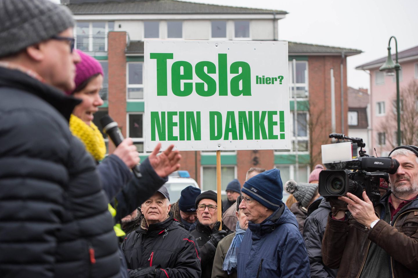 Nicht alle Brandenburger sind glücklich über die Ansiedlung von Tesla in der Nachbarschaft: Es gibt Demonstrationen, Plakate werden aufgehängt. Die Kritik der Demonstrierenden: Für die Fabrik würden große Flächen Wald gerodet, außerdem könnte die Trinkwasserversorgung beeinträchtigt werden.