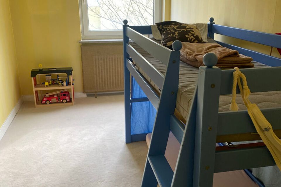 Kinderzimmer mit blauem Hochbett vor gelber Wand