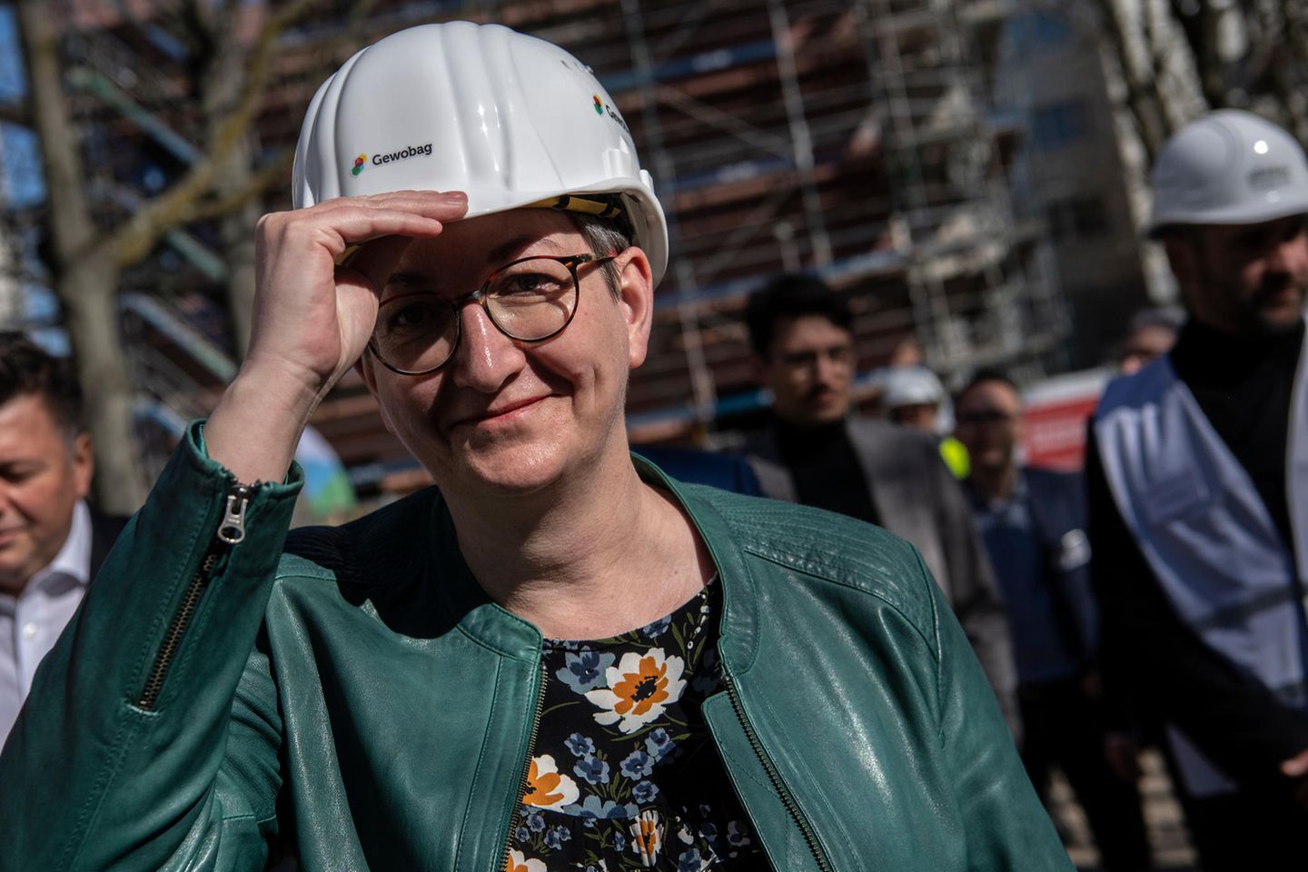 Bundesbauministerin Klara Geywitz setzt sich beim Baustellenrundgang auf dem Gelände der Buckower Höfe einen Bauhelm auf