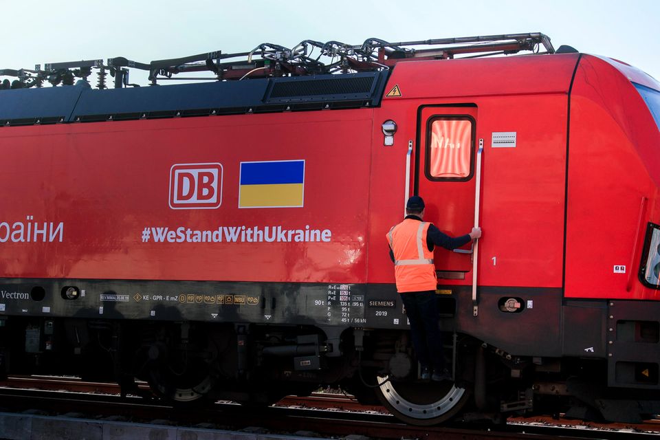 Der Lokführer eines Zuges mit Hilfsgütern für die Ukraine steigt vor der Abfahrt die Leiter zur Fahrkabine hinauf