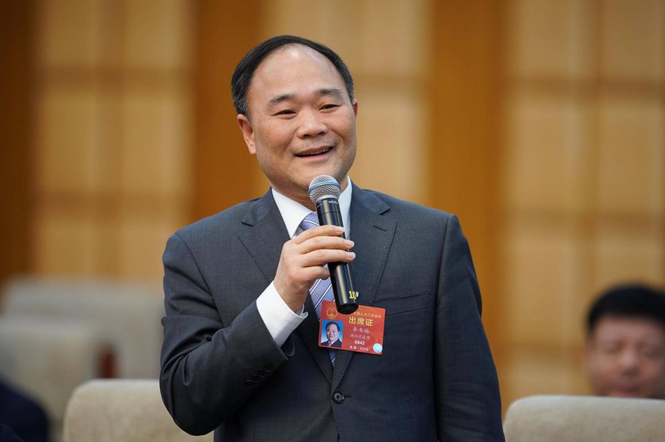 Li Shufu mit einem Mikrofon in der Hand