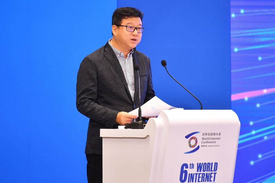 William Lei Ding an einem Pult mit Mikrofon