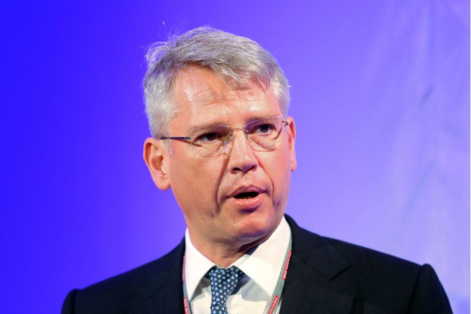 Charles Woodburn mit Brille und Anzug