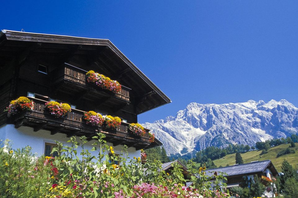 Ein mehrstöckiges altmodisches Haus an den Alpen