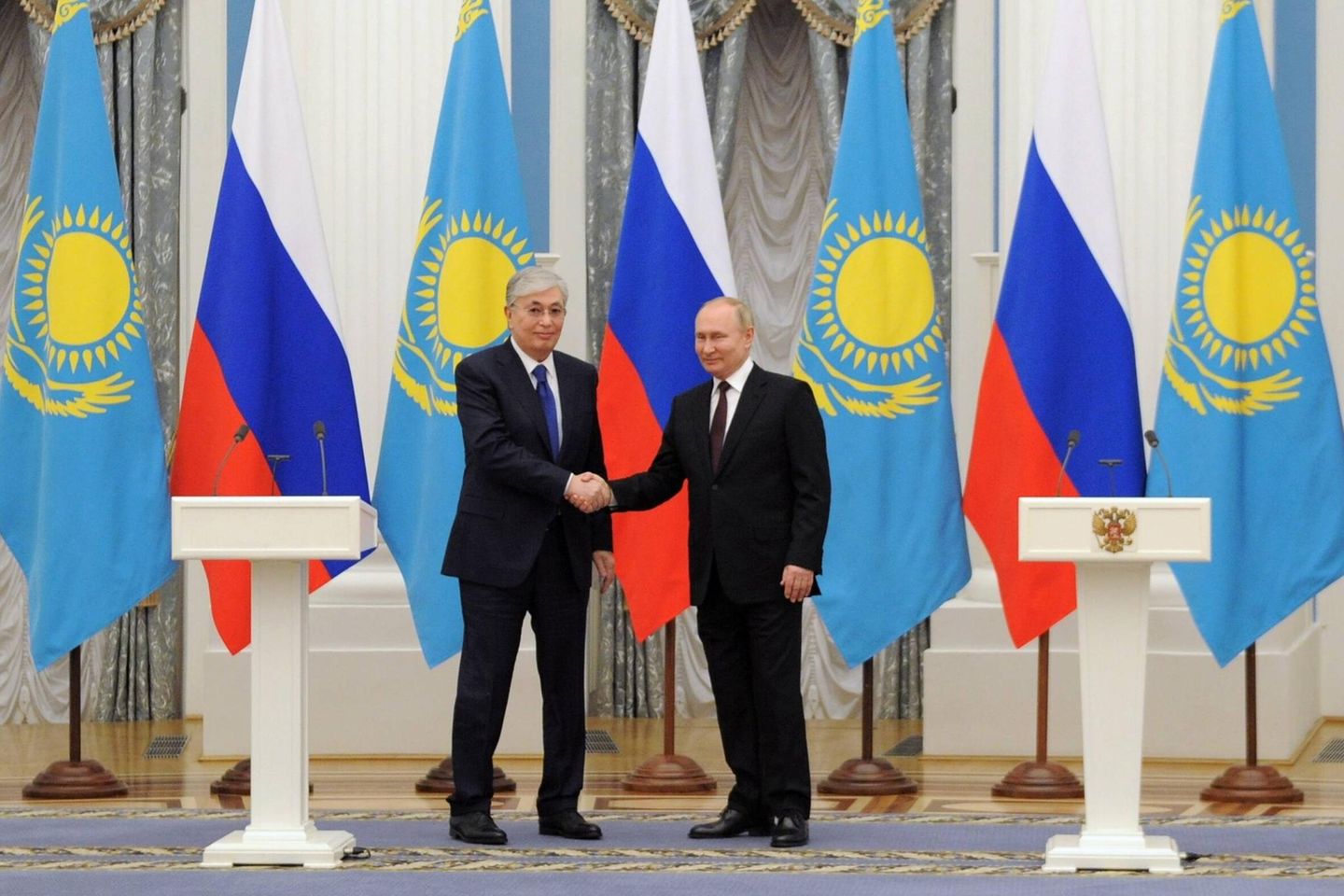 Der kasachische Präsident Tokajew schaut etwas gequält beim Händeschütteln mit Wladimir Putin