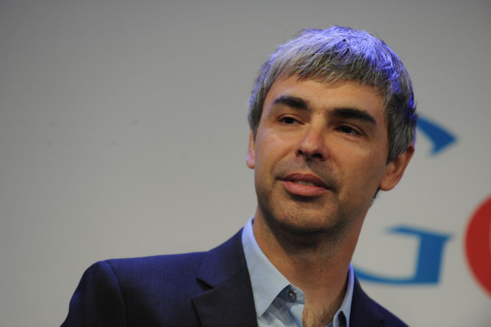 Larry Page mit mittellangen grau-melierten Haaren im schwarzen Anzug und blauen Hemd
