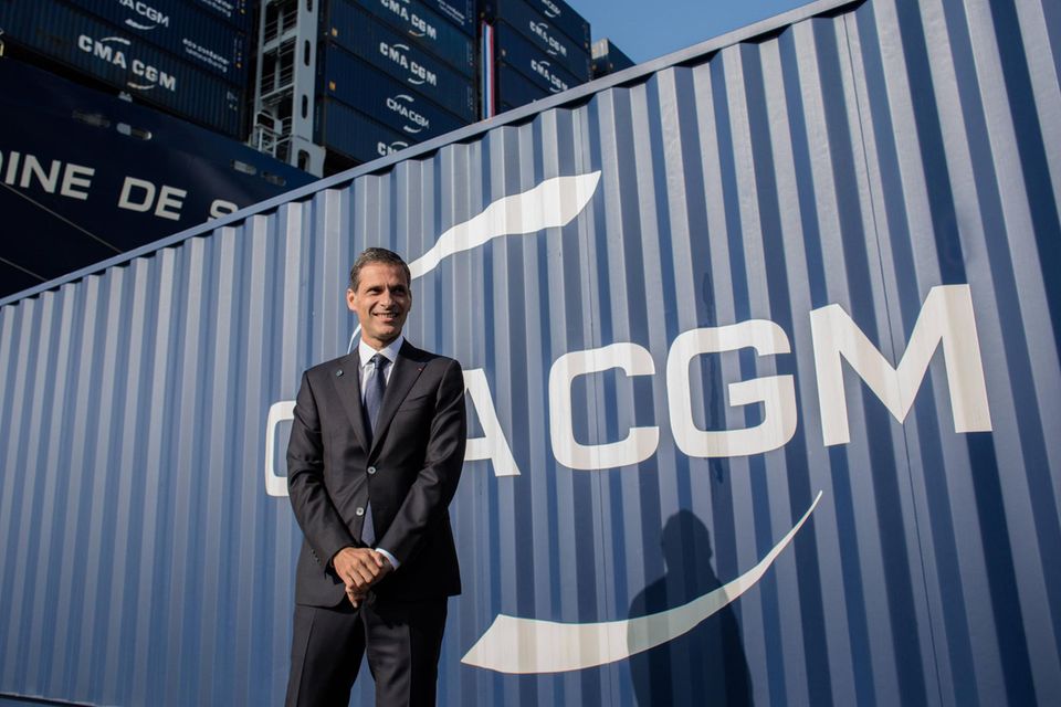 Rodolphe Saadé im Anzug vor einem CMA CGM Container.