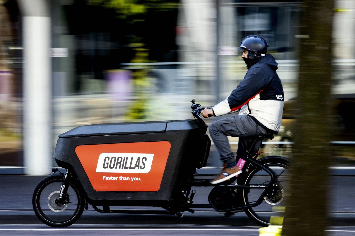 Ein Mann fährt mit einem Lastenrad des Lieferdienstes Gorillas