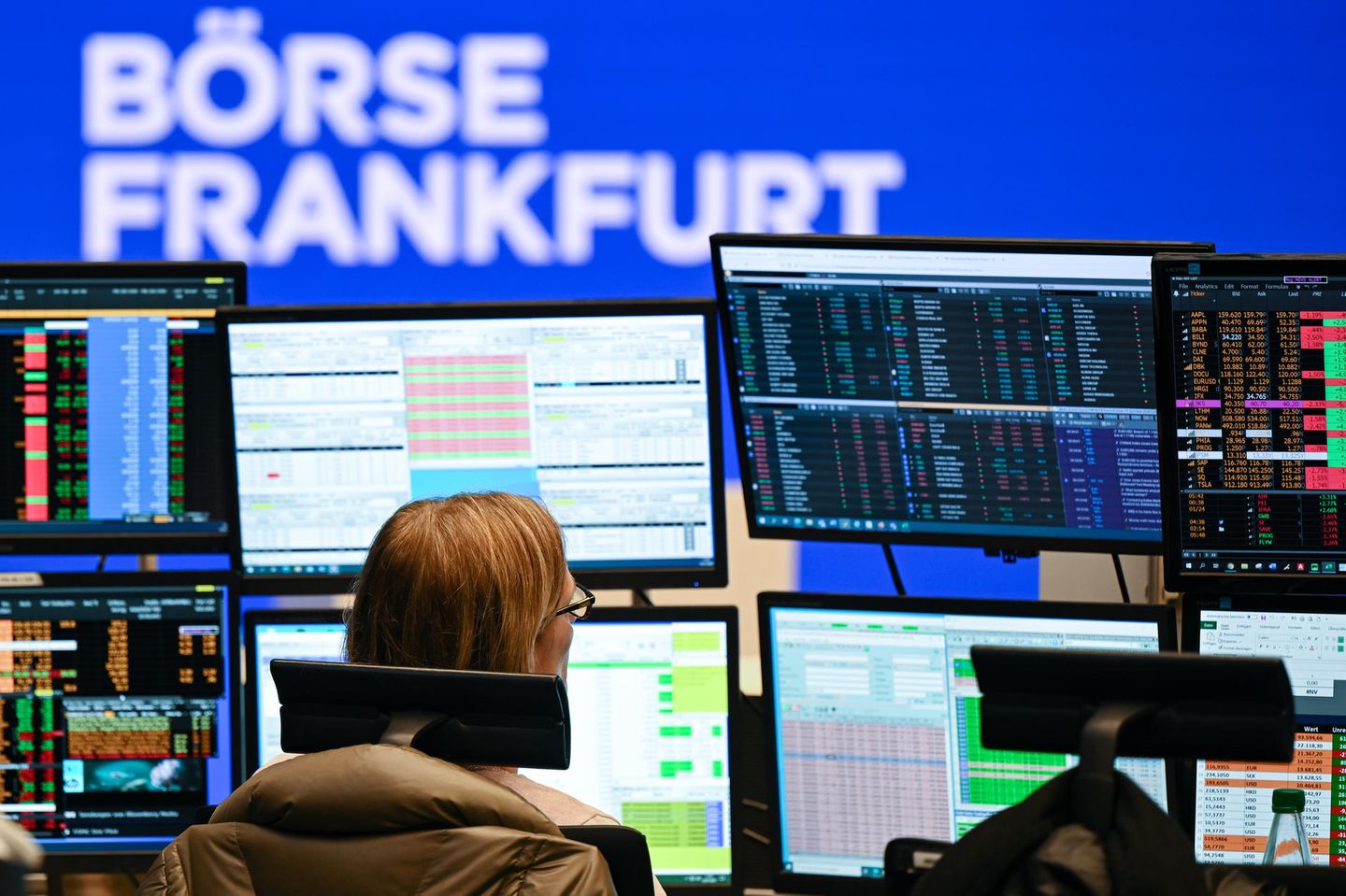 Eine Wertpapierhändlerin blickt an ihrem Arbeitsplatz auf dem Parkett der Frankfurter Wertpapierbörse auf ihre Monitore