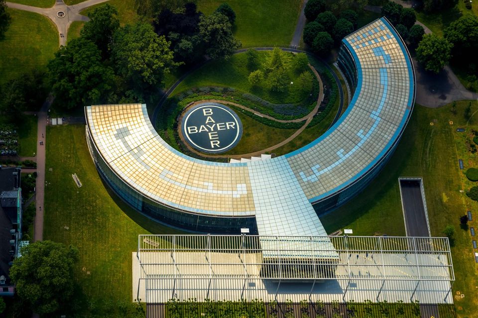 Der c-förmige Bayerhauptsitz mit Bayer-Logo im Hof aus der Vogelperspektive