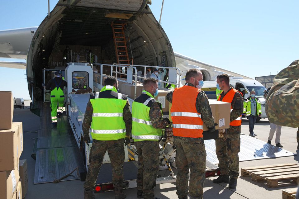 Bundeswehrsoldaten entladen die Antonow-Maschine auf dem Leipziger Flughafen