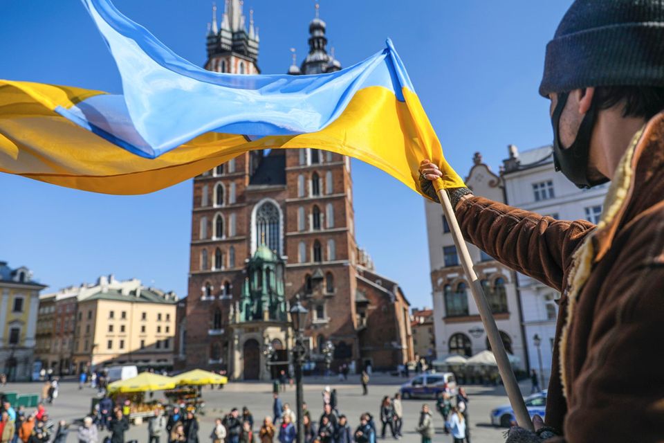 Ein Mann schwenkt bei einer Demonstration eine ukrainische Flagge