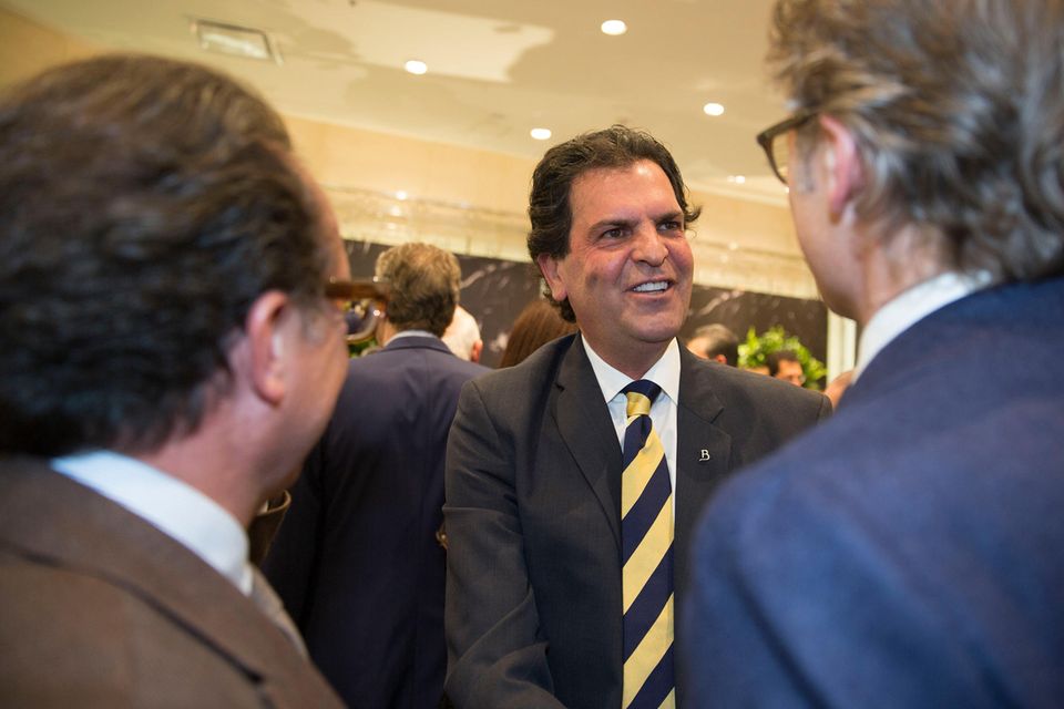 Alejandro Baillères lächelt und begrüßt einen Mann im blauen Anzug