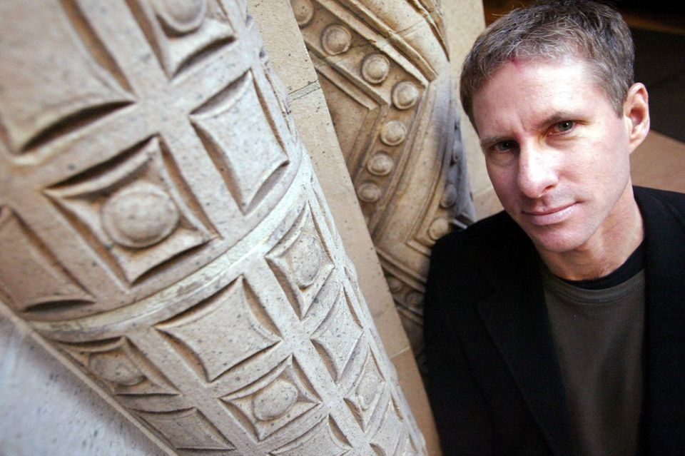 #5 Chris Larsen Chris Larsen an eine verzierte Steinmauer gelehnt