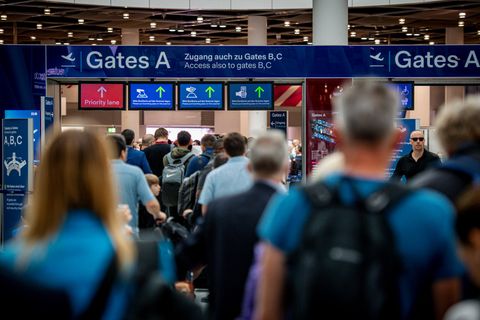 Flugreisende fliegen in den Urlaub und müssen in langen Warteschlangen stehen