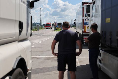 Lkw-Fahrer stehen neben ihren Lastwagen am Grenzübergang Tschernyschewskoje an der russisch-litauischen Grenze