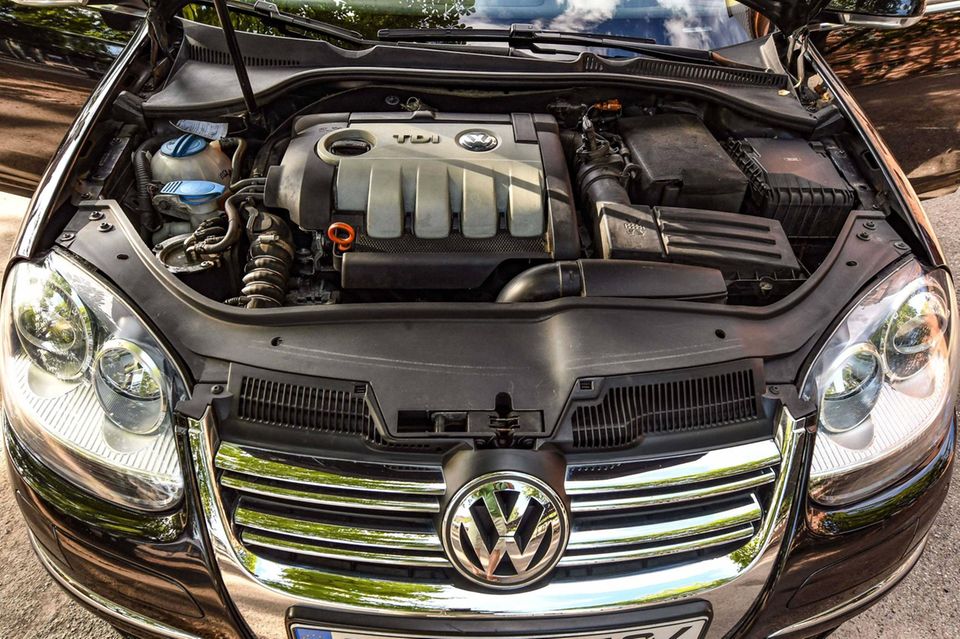 Blick unter die Motorhaube eines VW mit einem Verbrenner-Motor