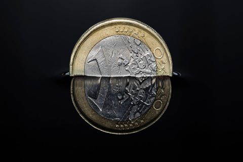 Euro-Münze in einer dunklen Flüssigkeit