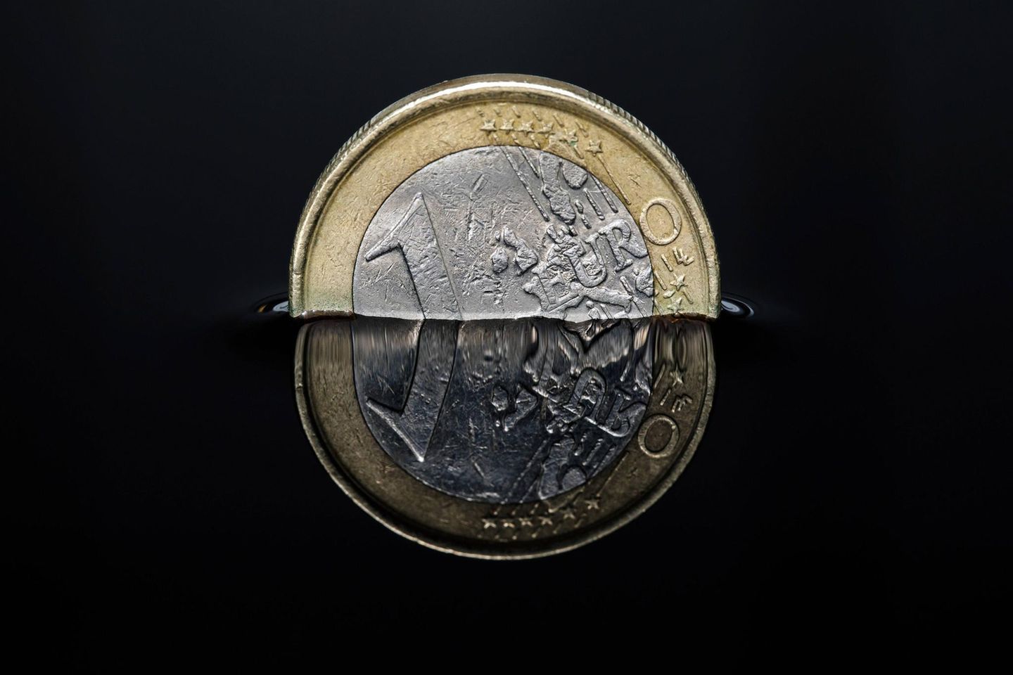 Euro-Münze in einer dunklen Flüssigkeit
