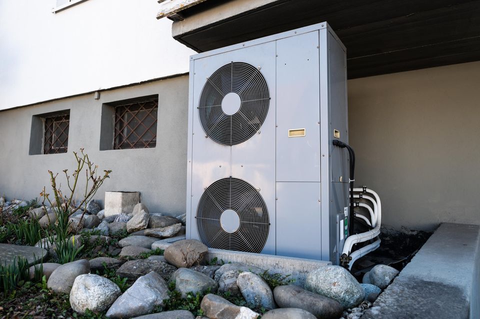 De Lüftungsanlage einer Wärmepumpe steht vor einem Wohnhaus