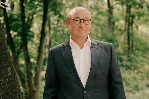 Vonovia-Chef Rolf Buch steht neben einem Baum im Berliner Tiergarten