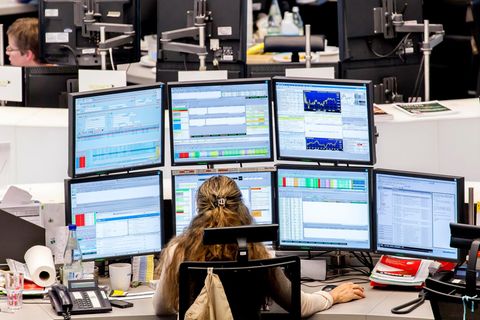 Eine Aktienhändlerin an der Frankfurter Börse schaut auf ihre Monitore