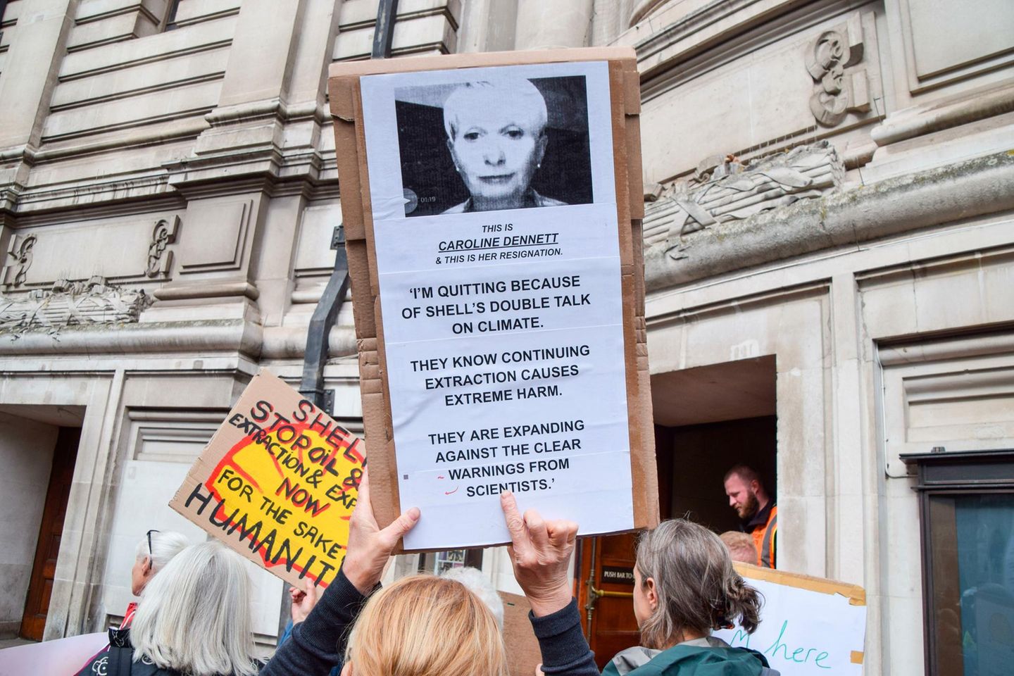 Ein Demonstrant hält ein Schild mit einem Zitat der ehemaligen Shell-Beraterin Caroline Dennett