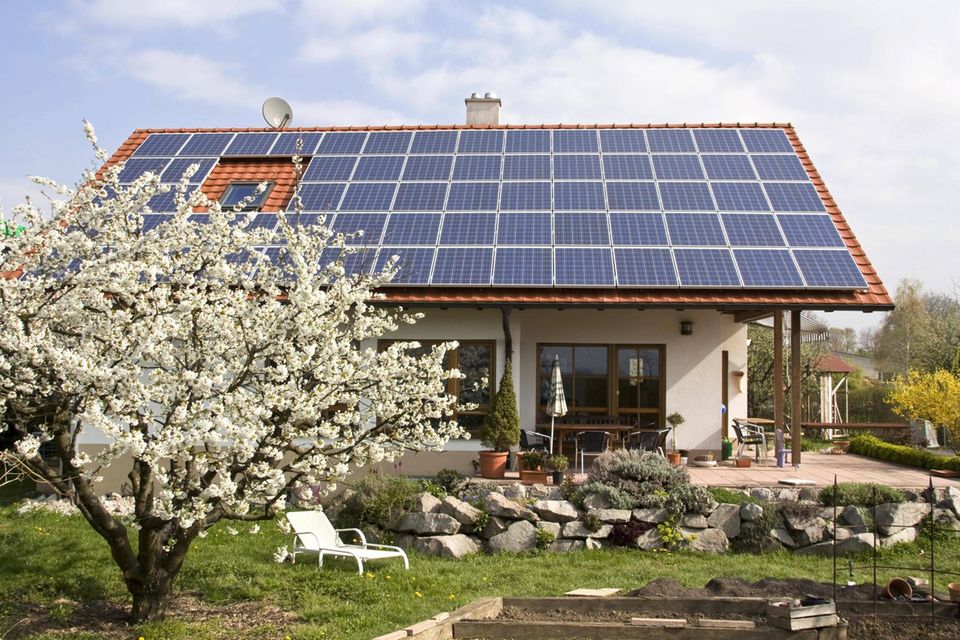 Ein Einfamilienhaus mit Solarzellen auf dem Dach.