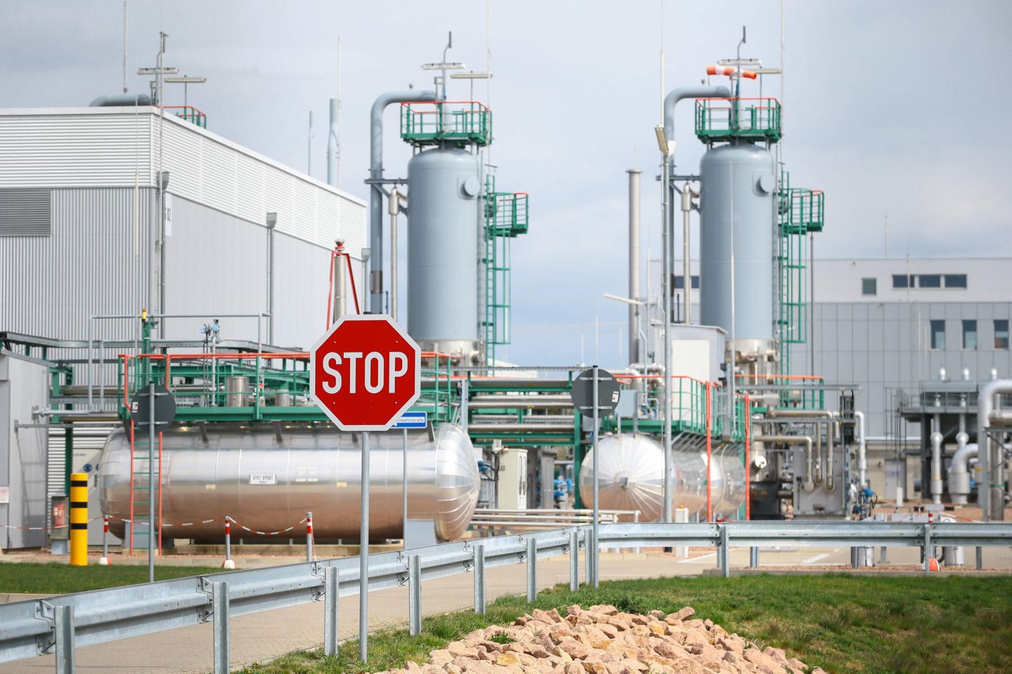 Blick auf den Gasspeicher Peissen mit einem Stoppschild im Vordergrund