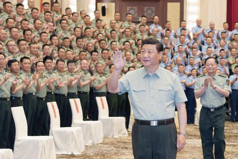 Xi Jinping geht winkend an Offizieren der Armee vorbei, die ihm stehend applaudieren