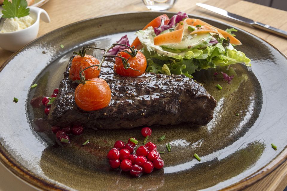 Ein Steak mit Tomaten und Salat auf einem Teller