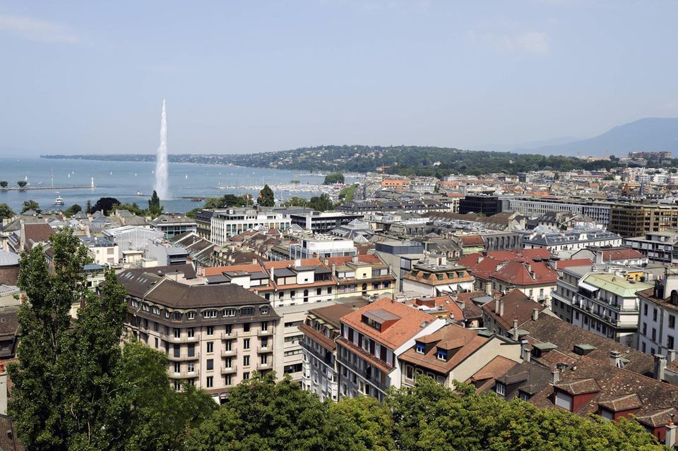 Hinter den Dächern Genfs liegt der Genfer See