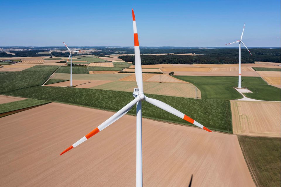 Ein Windkraftwerk mit Feldern im Hintergrund