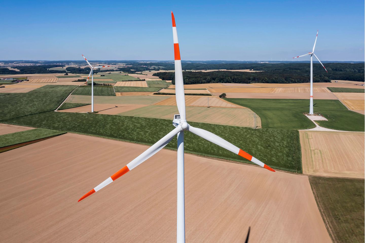 Ein Windkraftwerk mit Feldern im Hintergrund