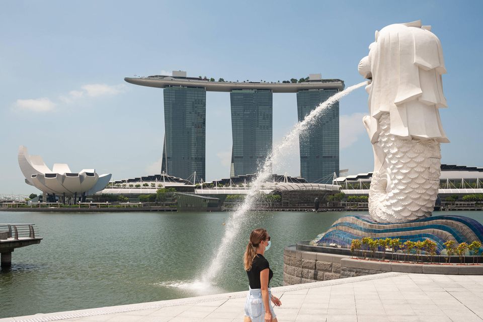 Eine Promenade in Singapur mit einem Wasserspeier und dem Marina Bay Sands im Hintergrund