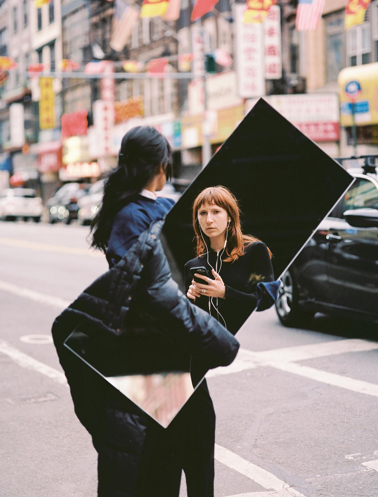 Adam Whyte, New York: „Die Arbeiten von William Klein brachen mit den Schemata seiner modernistischen Zeitgenossen in der Fotografie. Er blieb keinem Stil oder Genre treu, sondern ließ jedes Bild für sich stehen. Mit meiner Neuinterpretation wollte ich ein Gespräch zwischen der Lebenswirklichkeit damals, in den Sechzigern, und heute anstoßen: Wie Klein zeige ich ein Model auf der Straße, nur dass es sich als nicht-binär identifiziert und mit eingesteckten Kopfhörern und iPhone in der Hand abgelichtet wird. Akustisch abgekoppelt von der Metropole, die es umgibt. Neugierig blickt es durch den Spiegel in die Kameralinse und sieht damit direkt zum Betrachter hin.“