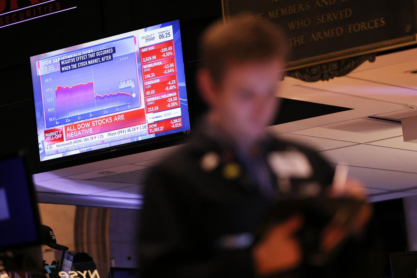 Finanznachrichten laufen auf einem Bildschirm, während Händler auf dem Parkett der New Yorker Börse arbeiten