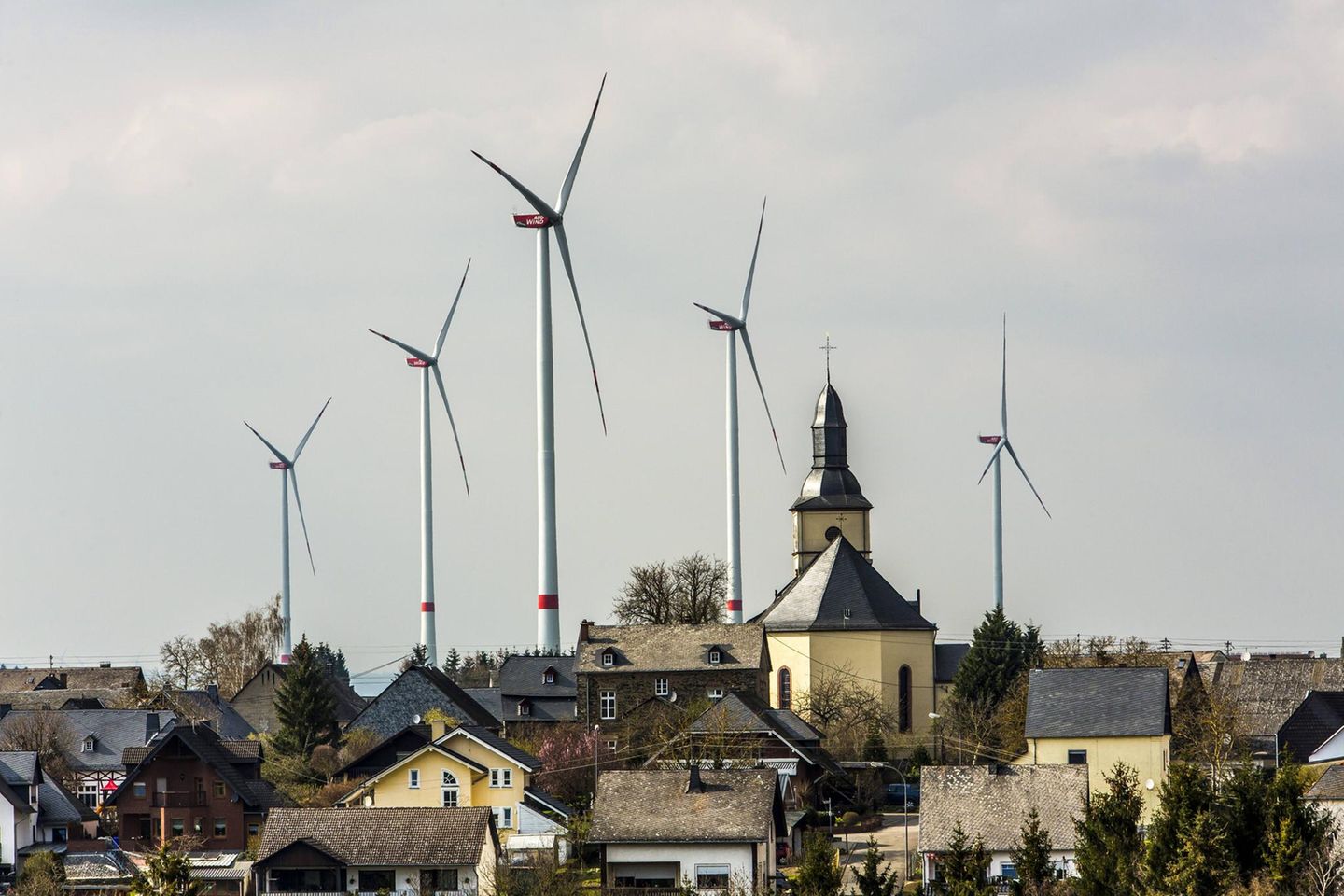 Kirche, dahinter Windräder