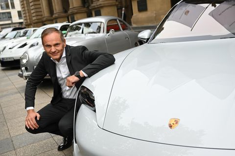 Oliver Blume, Vorstandschef von Volkswagen und Porsche, kniet beim Börsengang der Porsche AG vor der Frankfurter Börse an einem Porsche Taycan Turbo S. Der elektrische "Taycan" ist seit Januar das meistverkaufte Modell der Marke.