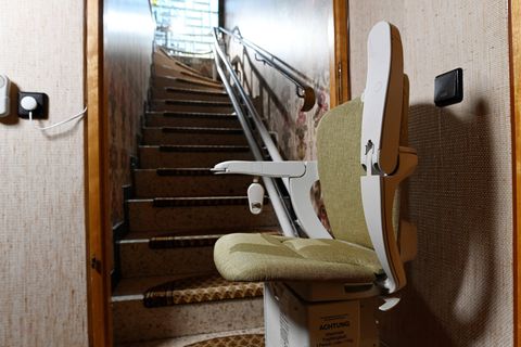 Ein Treppenlift steht unten an einer Treppe