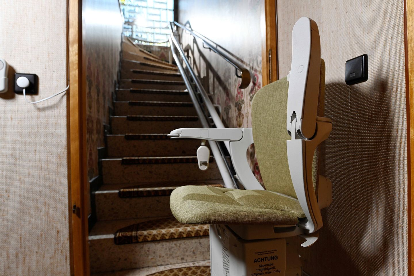 Ein Treppenlift steht unten an einer Treppe