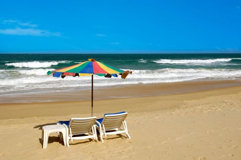 Einsamer Strand mit Sonnenschirm und Liegestuhl am Strand von Phuket in Thailand