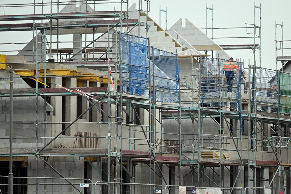Gerüste stehen an noch nicht fertig gebauten Häusern in einem Neubaugebiet